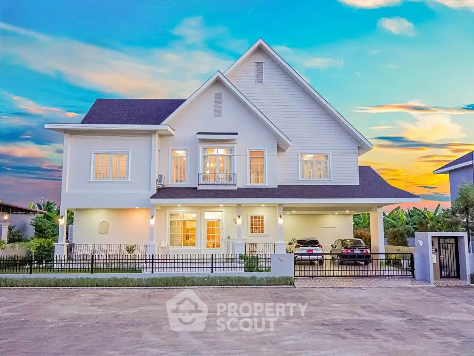 Stunning two-story white house with spacious driveway and sunset backdrop, perfect for luxury living.