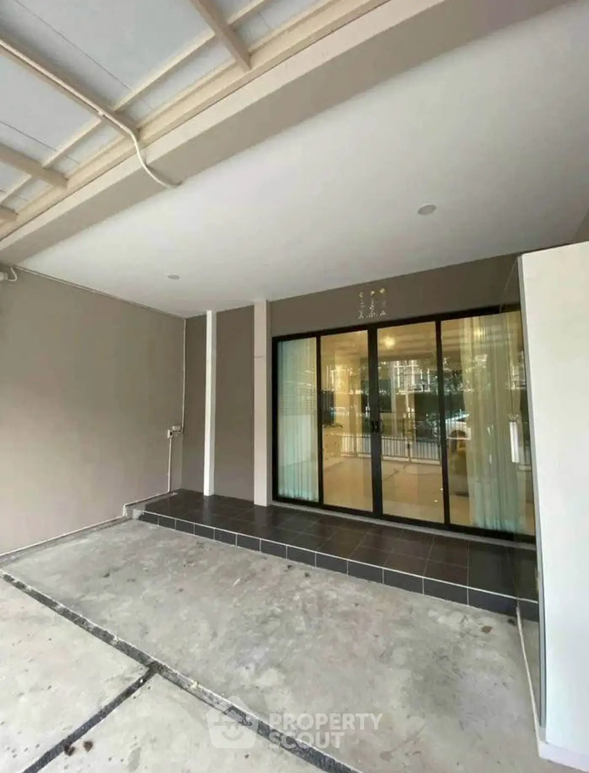 Spacious modern entrance with sleek glass doors and tiled flooring