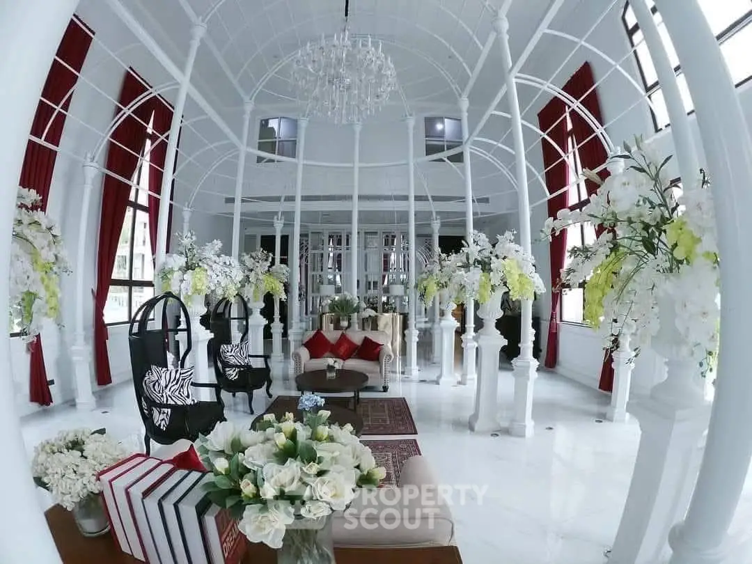 Luxurious living room with elegant decor and floral arrangements in a spacious setting.