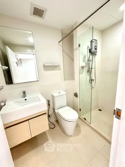 Modern bathroom with glass shower and sleek fixtures in a contemporary apartment.