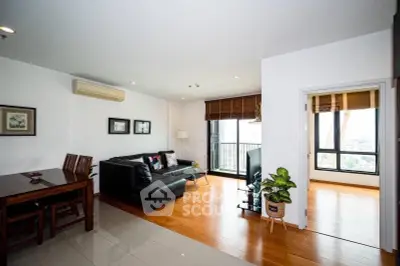 Spacious modern living room with balcony and stylish decor in a high-rise apartment.
