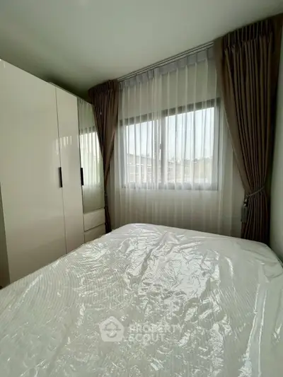 Cozy bedroom with large window and modern wardrobe, perfect for natural light lovers.