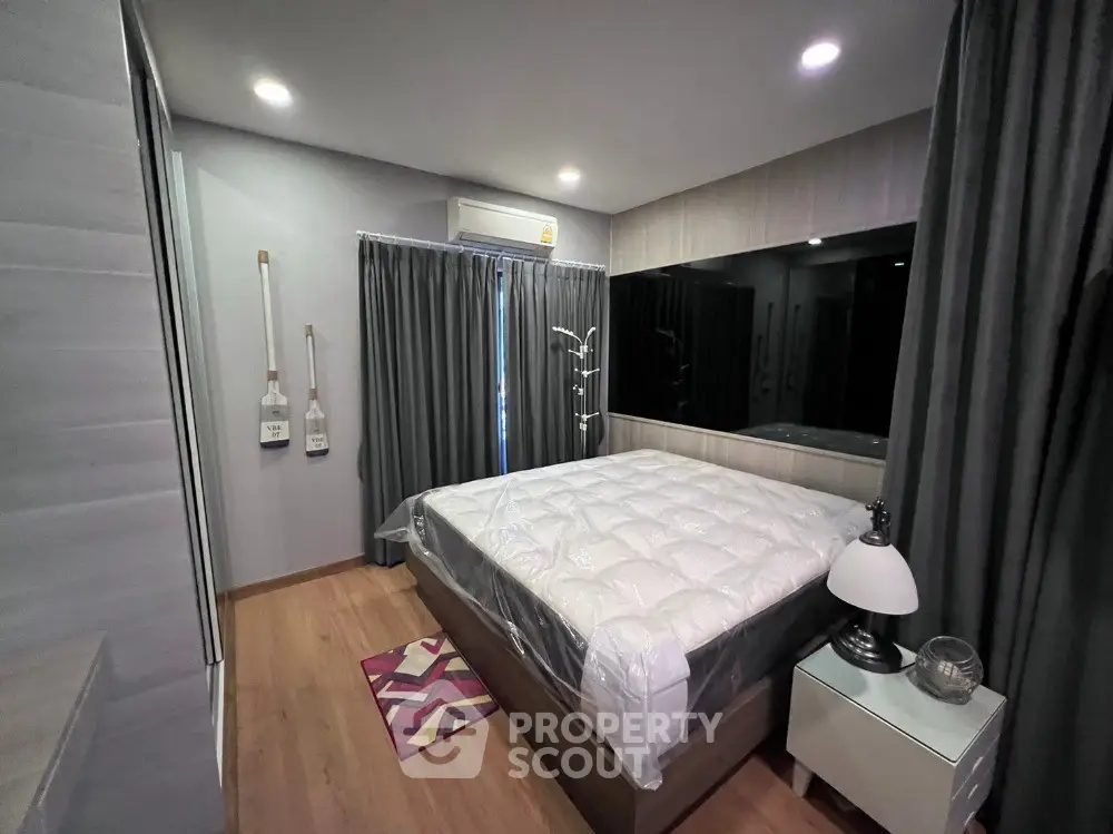 Modern bedroom with cozy lighting and stylish decor, featuring a comfortable bed and elegant curtains.