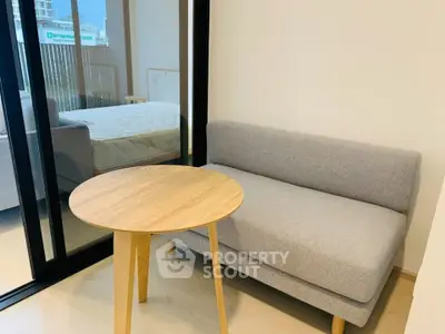 Cozy modern living area with sofa and wooden table near bedroom