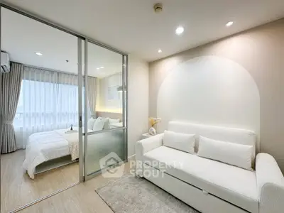 Modern studio apartment with cozy living area and bedroom separated by glass partition.