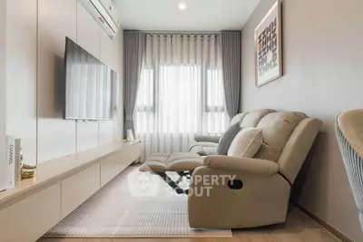 Modern living room with sleek furniture and large window, perfect for relaxation and entertainment.