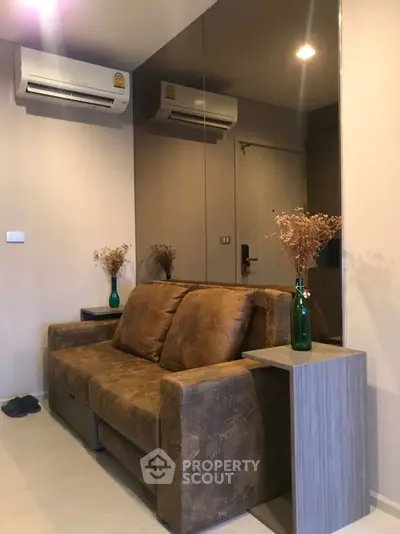 Cozy living room with brown leather sofa and modern air conditioning unit