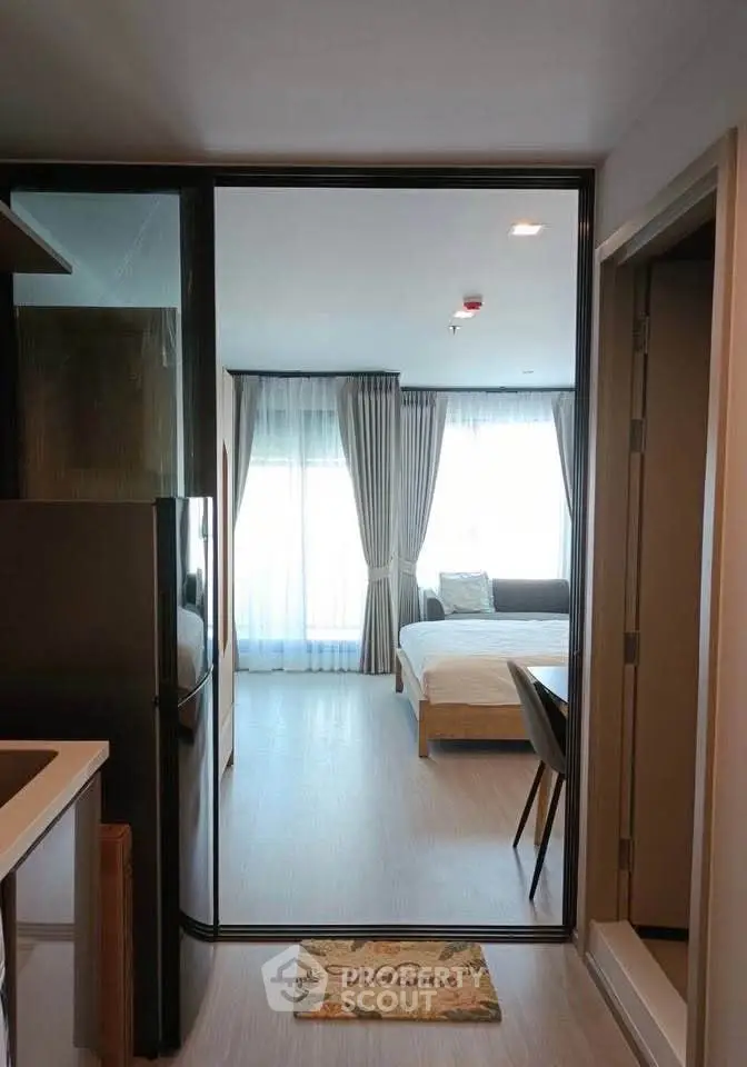 Modern studio apartment with open layout, featuring a cozy bedroom and sleek kitchen area.