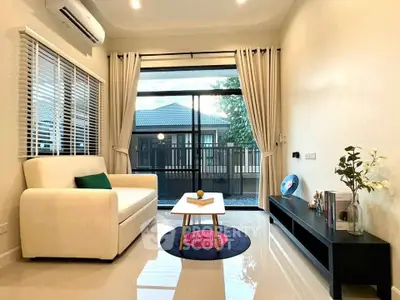 Modern living room with sleek furniture and large window offering a serene view, perfect for relaxation.