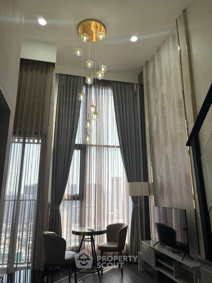 Luxurious high-ceiling living room with elegant chandelier and floor-to-ceiling windows offering stunning city views.