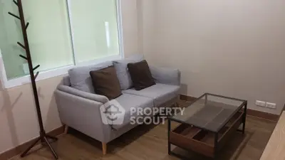 Cozy living room with modern gray sofa and glass coffee table, perfect for relaxation.