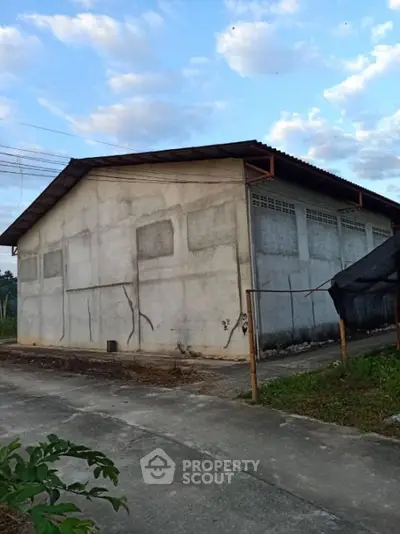 Industrial warehouse exterior with concrete walls and metal roof