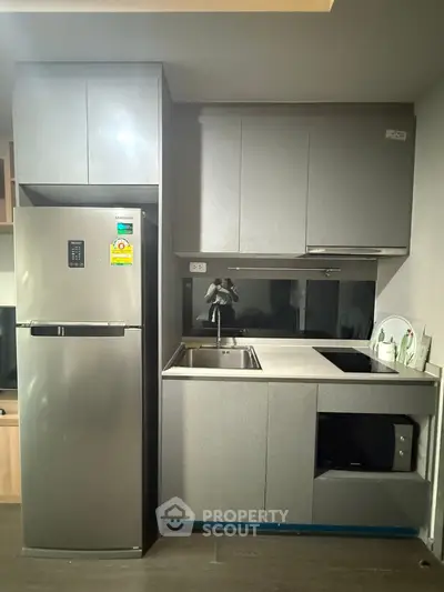 Modern kitchen with sleek cabinets, stainless steel fridge, and built-in appliances.