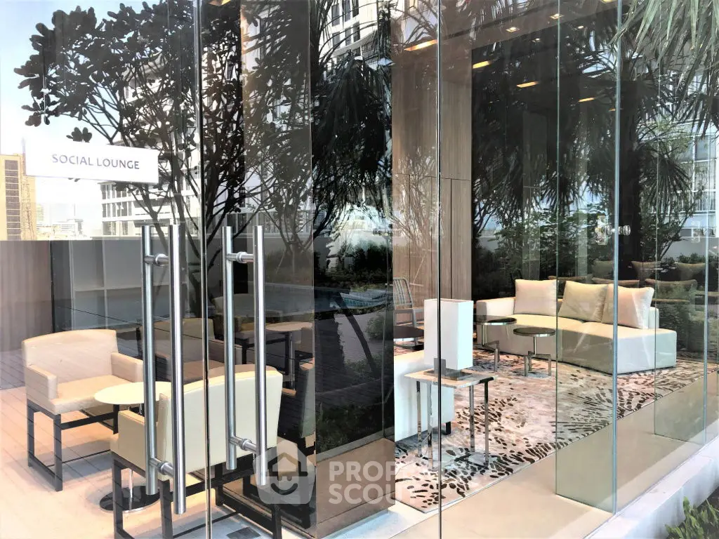 Luxurious social lounge with modern seating and glass walls offering stunning city views.