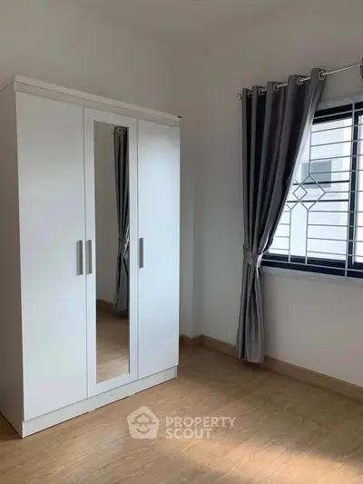Bright bedroom with wooden flooring and modern wardrobe