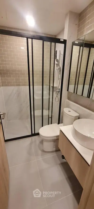 Modern bathroom with glass shower and sleek fixtures in a contemporary apartment.