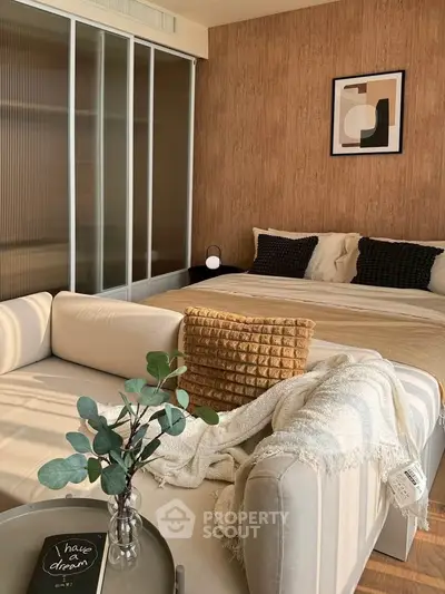 Cozy bedroom with stylish decor and natural light, featuring a comfortable bed and modern furnishings.