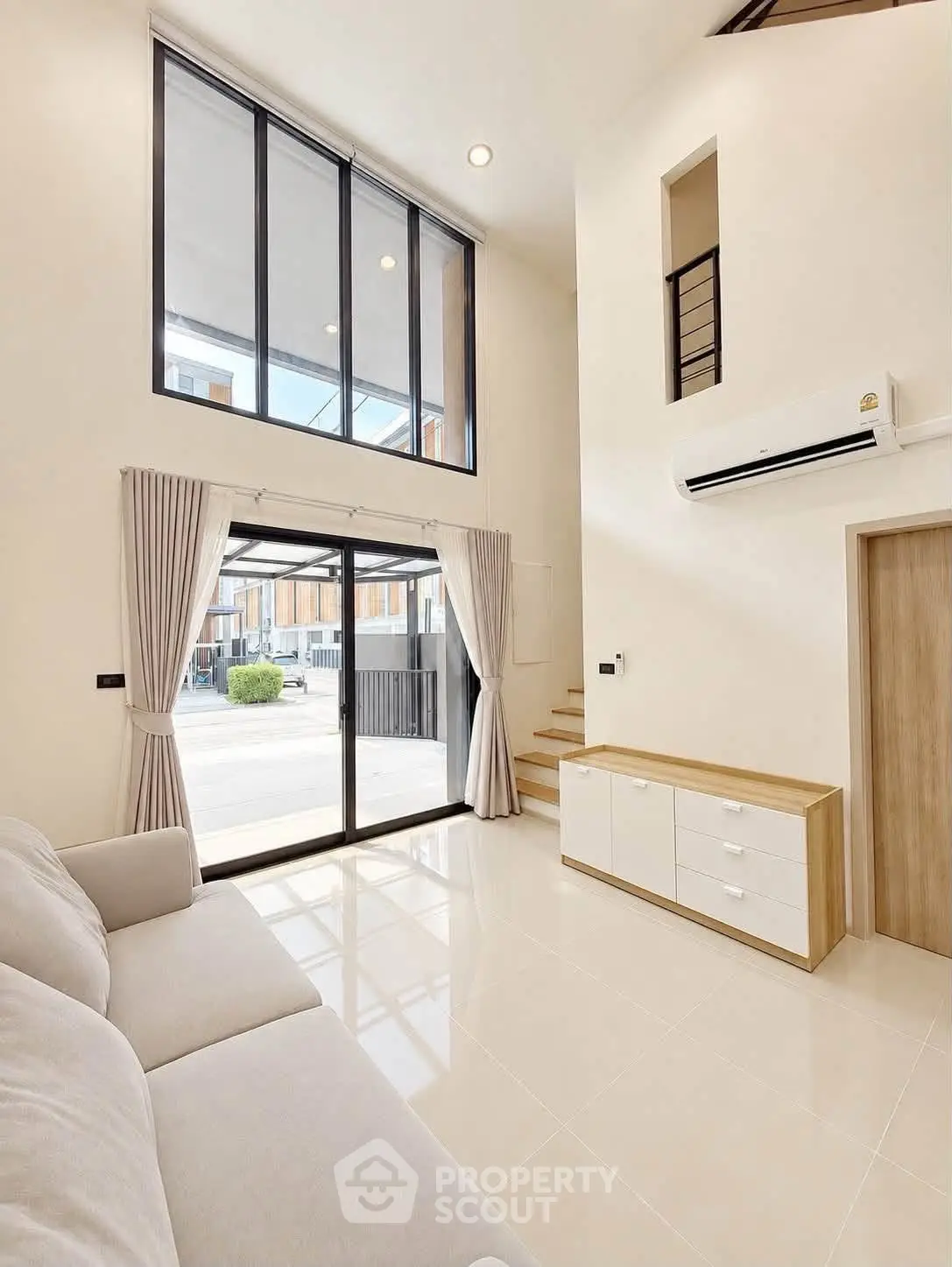 Spacious modern living room with high ceilings and large windows