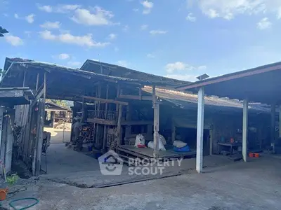 Rustic wooden barn with open layout under clear blue sky