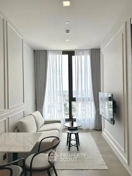 Stylish modern living room with city view, featuring elegant decor and natural light.