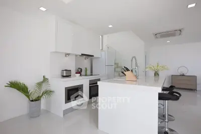 Modern white kitchen with sleek design and open layout