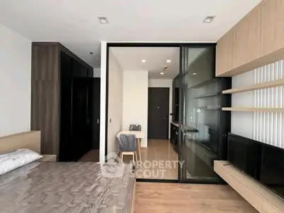 Modern studio apartment with sleek design and open layout, featuring a cozy bedroom and stylish kitchen.