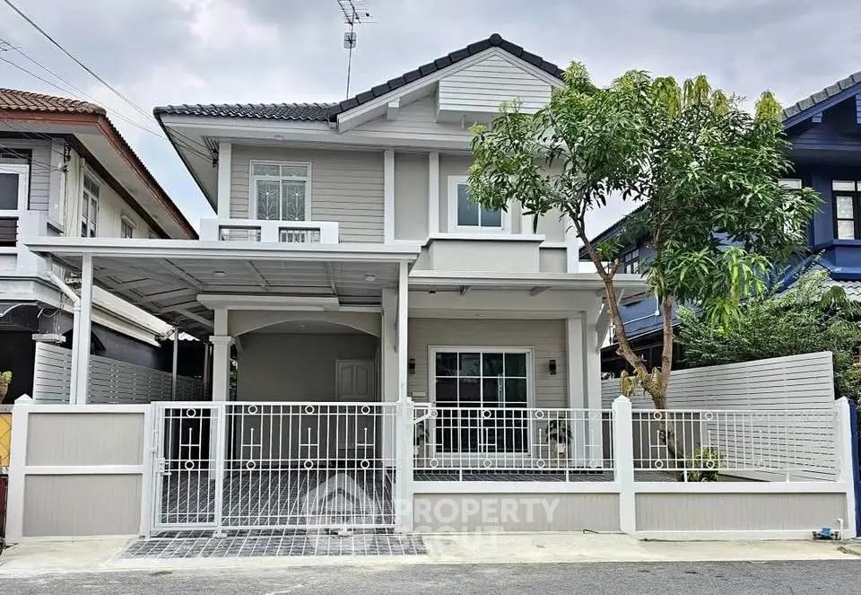 Charming two-story house with modern design and gated entrance in a serene neighborhood.