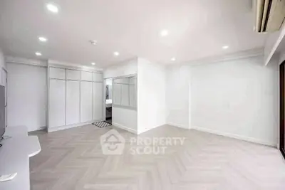 Spacious modern living room with elegant flooring and ample natural light
