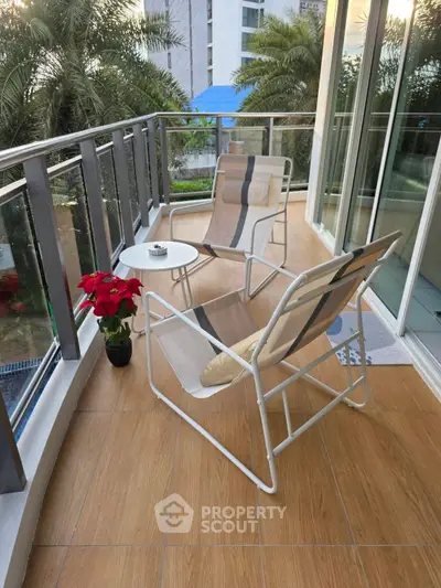 Charming balcony with modern chairs and lush greenery view, perfect for relaxation.