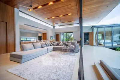 Luxurious open-plan living room with modern design and spacious layout, featuring elegant furniture and natural light.