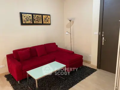 Cozy living room with red sofa and modern decor, perfect for relaxation.