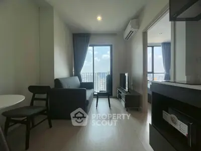 Modern living room with city view, featuring sleek furniture and natural light.