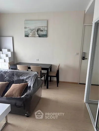 Modern living room with stylish furniture and artwork, featuring a cozy dining area and sleek design.
