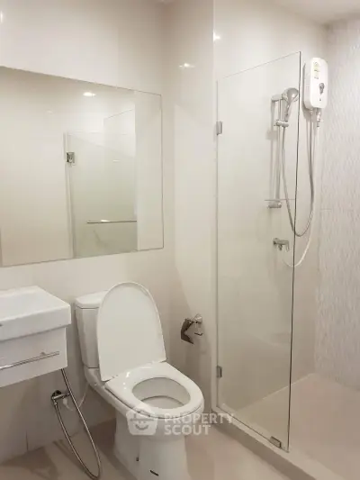 Modern bathroom with glass shower and sleek fixtures in a contemporary apartment.