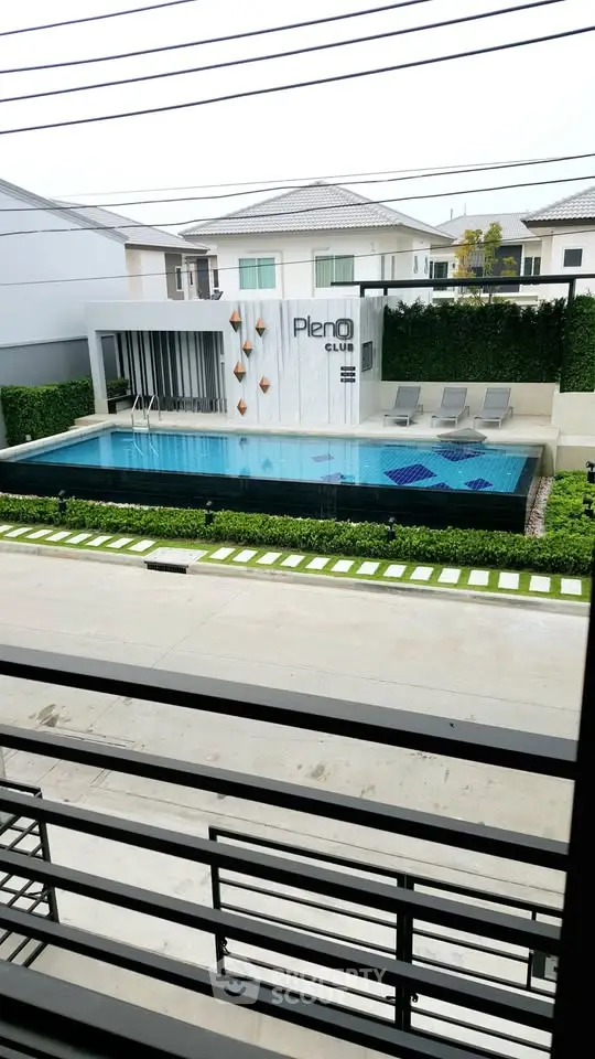 Modern residential complex with stylish pool and lounge area, perfect for relaxation and leisure.