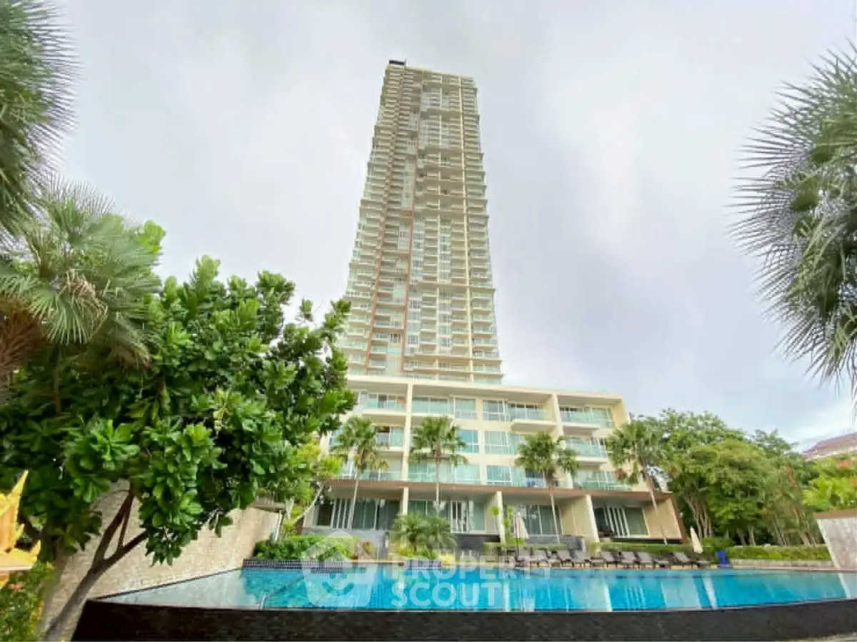 Luxurious high-rise building with pool and lush greenery, perfect for upscale living.