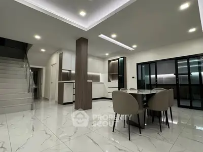 Modern open-plan living area with sleek kitchen and dining space, featuring elegant marble flooring.