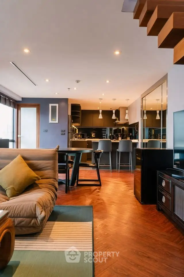 Modern open-plan living room with stylish kitchen and wooden flooring