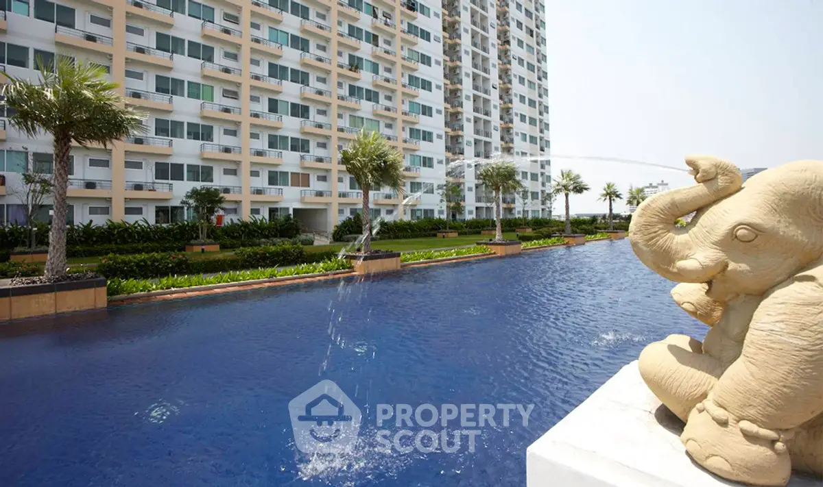Luxurious apartment complex with stunning pool and elegant elephant fountain.