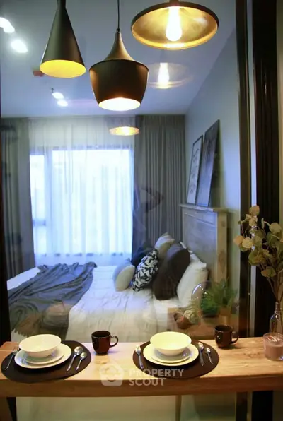 Cozy bedroom view with elegant lighting and dining setup, perfect for modern living.