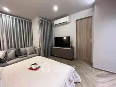 Modern bedroom with cozy bed, TV, and air conditioning in stylish apartment.