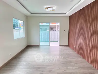 Spacious modern living room with wooden flooring and stylish ceiling light.
