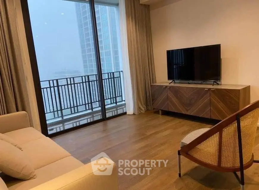 Modern living room with large window and stylish furniture in high-rise apartment.