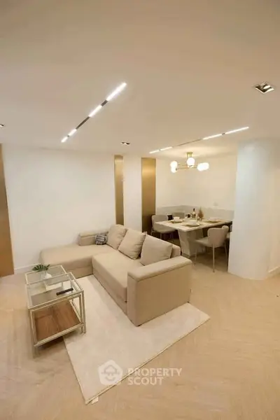 Modern living room with beige sectional sofa and elegant dining area