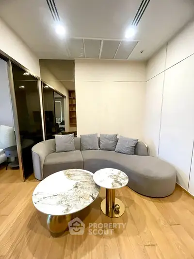 Stylish modern living room with unique marble coffee tables and cozy gray sofa, perfect for relaxation.