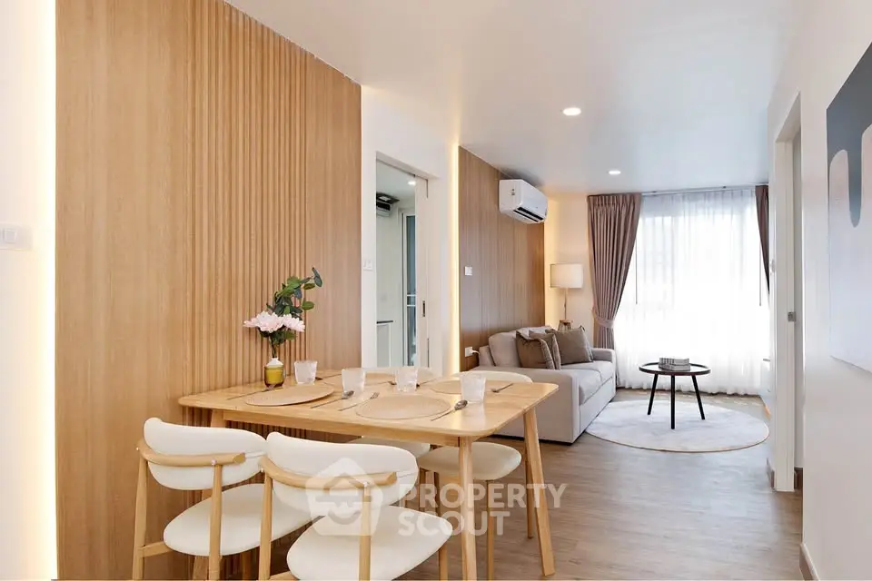 Modern living room with wooden accents and cozy dining area in a stylish apartment.
