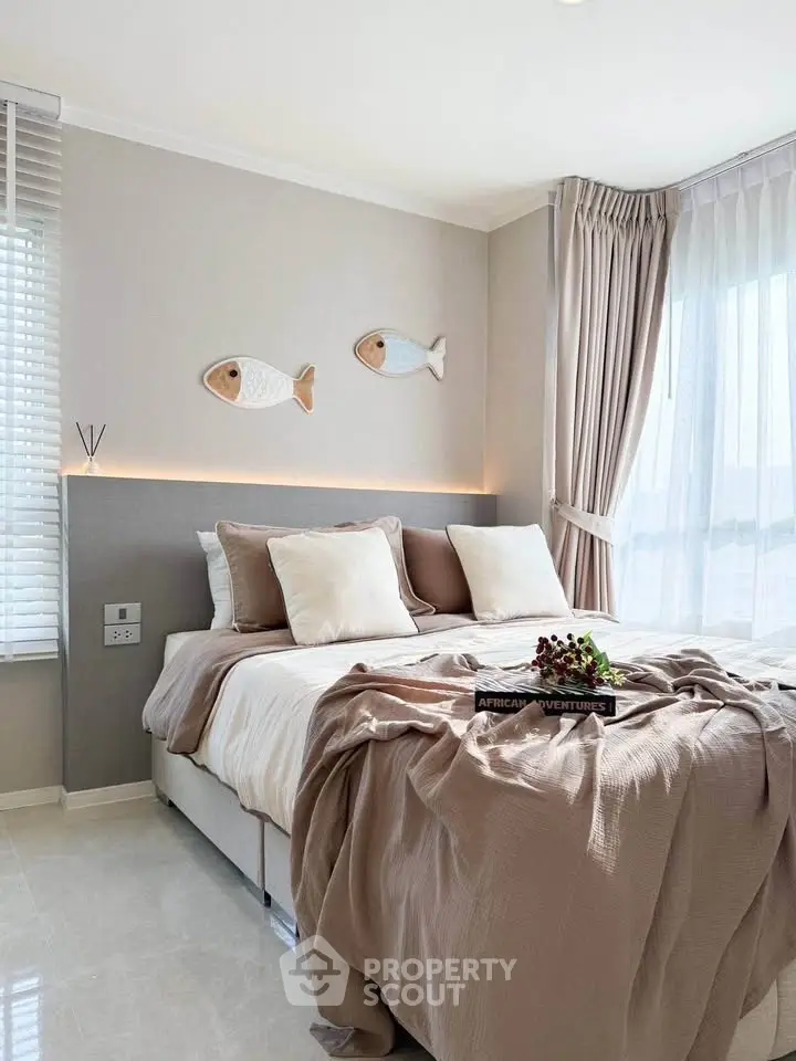 Elegant bedroom with cozy decor and natural light, featuring stylish fish wall art and plush bedding.