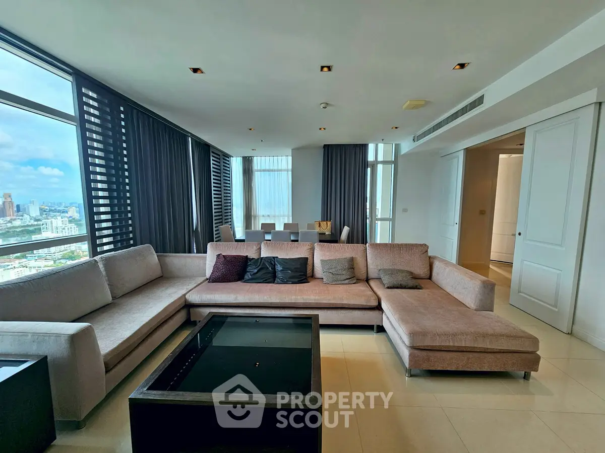Spacious modern living room with panoramic city views and elegant furnishings.