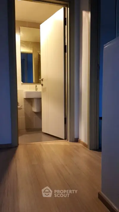 Modern bathroom entrance with sleek wooden flooring and minimalist design