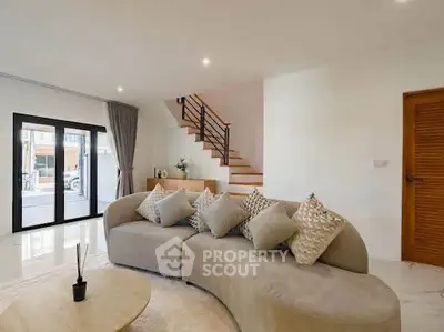 Spacious modern living room with elegant curved sofa and stylish staircase